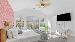 A bedroom with a bed, a desk, a TV, and a ceiling fan. - The Salty Flamingo w Pool+Hot Tub+Ping Pong (Murrayville)