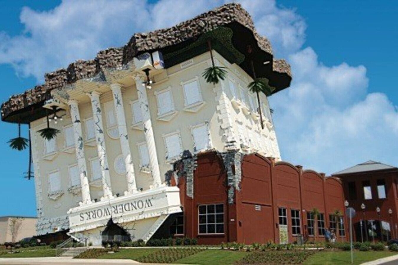 A building with a unique architectural design, featuring a white facade with decorative elements and a brown lower section.