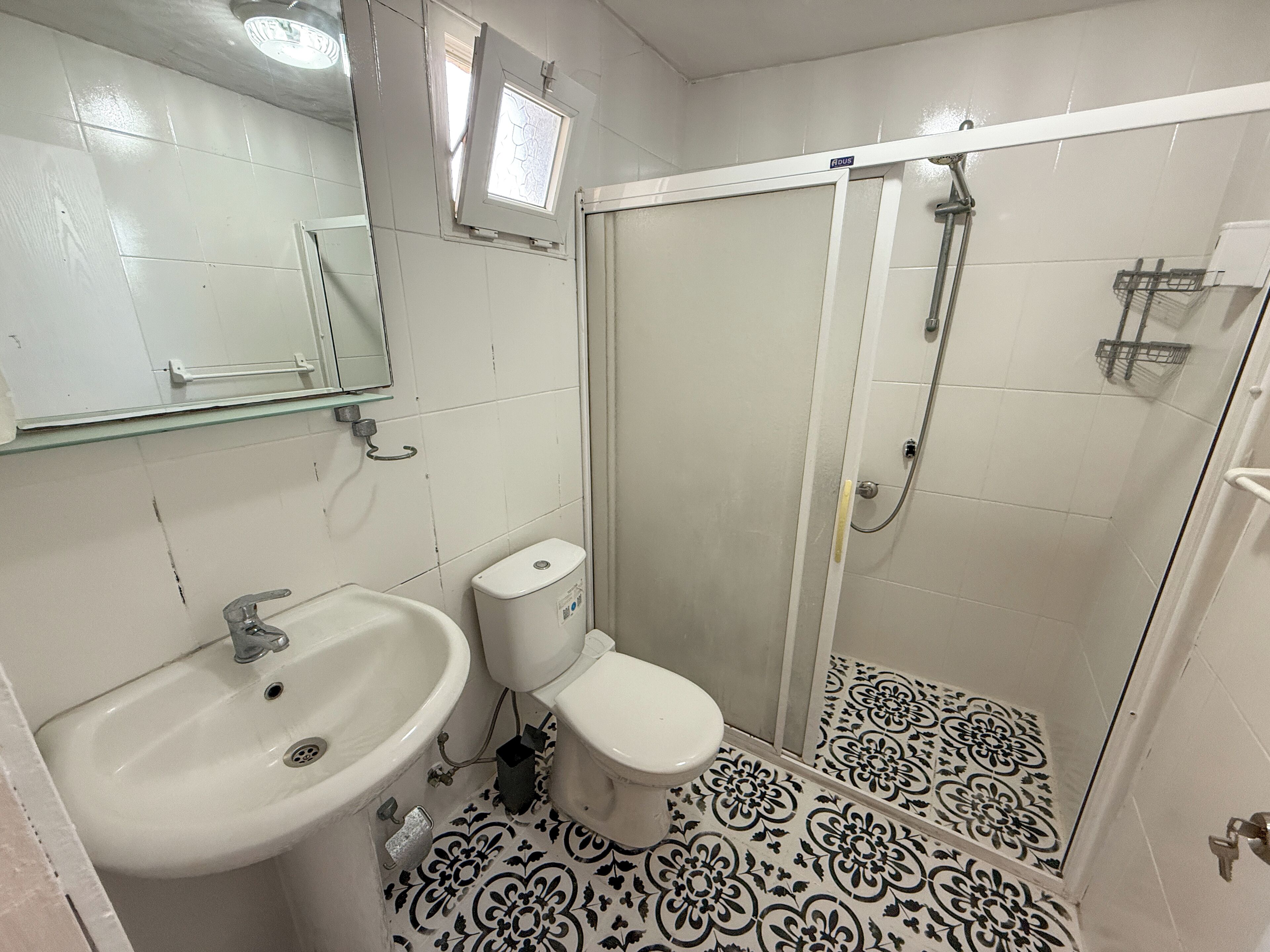 Un baño con lavamanos, inodoro y ducha.