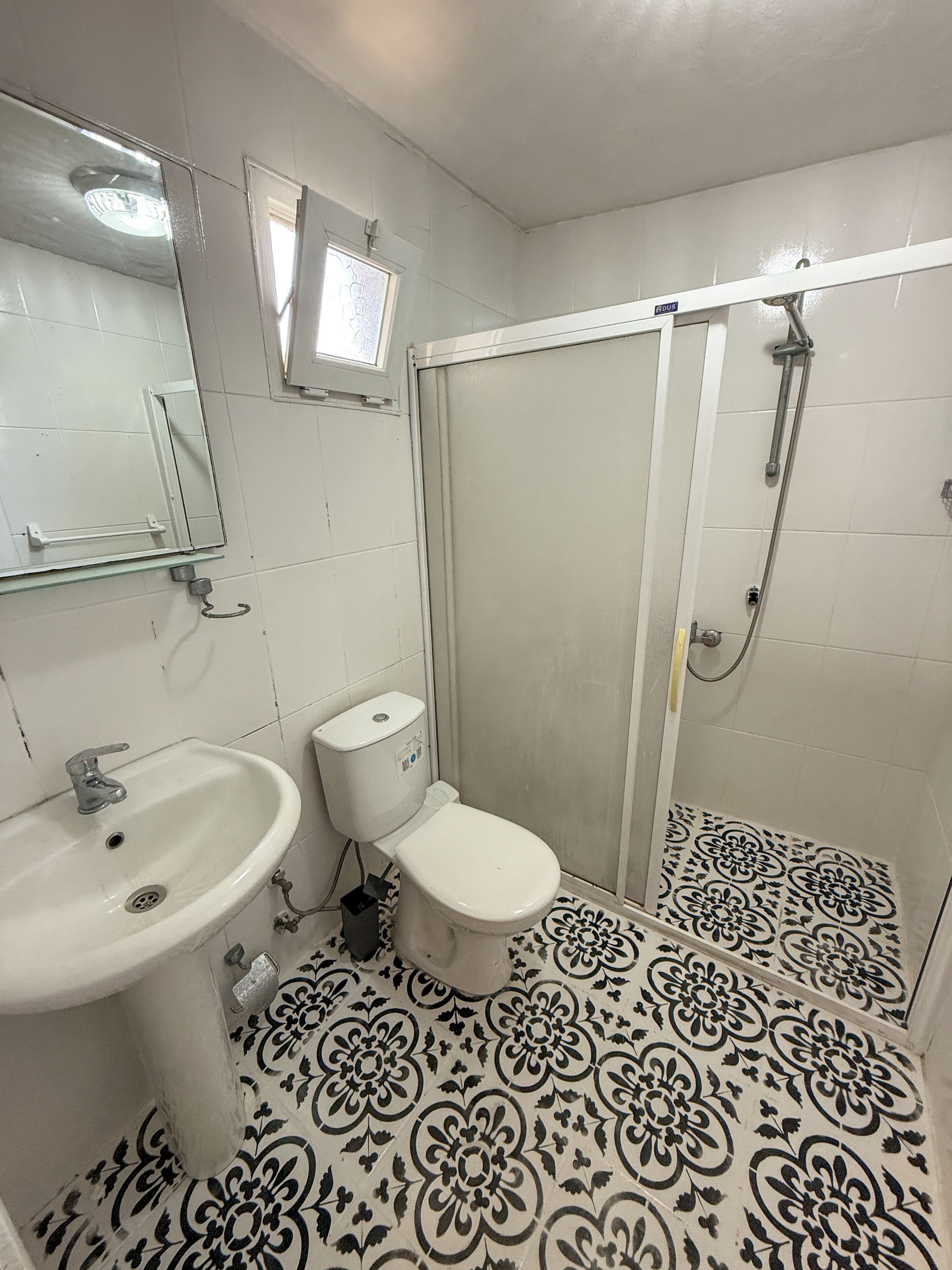 A bathroom with a sink, toilet, and shower.