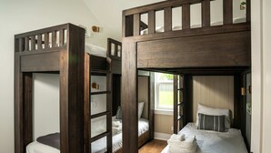 Une pièce avec deux lits superposés, une fenêtre et une porte.