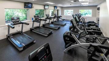 A gym with treadmills, stationary bikes, and elliptical machines.