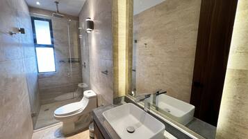 Un baño moderno con inodoro, lavabo y ducha.