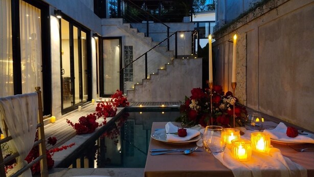 A romantic outdoor dining setup with a table, candles, and flowers. - 3-bedroom villa in fabulous Uluwatu Bali with pool (Bali)