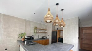 A modern kitchen with a large island, pendant lights, and wooden stools. - 3-bedroom villa in fabulous Uluwatu Bali with pool (Bali)
