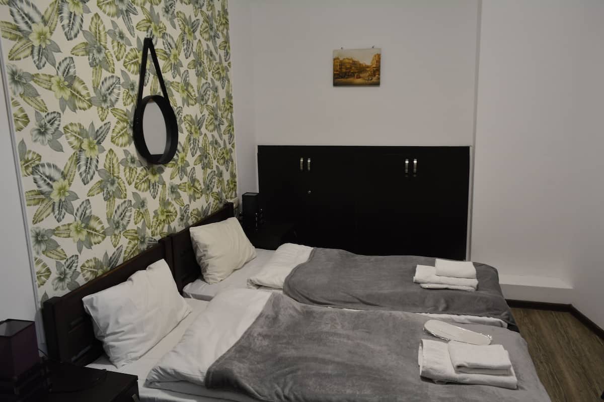 A hotel room with a bed, pillows, and neatly folded towels.