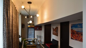 A hotel lobby with a staircase, seating area, and a refrigerator. - Hotel Nino on Tsamebuli (Tbilisi)