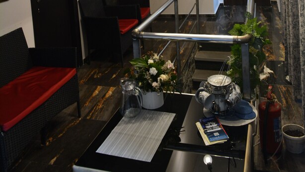 A modern hotel lobby with a reception desk, seating area, and artwork on the walls. - Hotel Nino on Tsamebuli (Tbilisi)