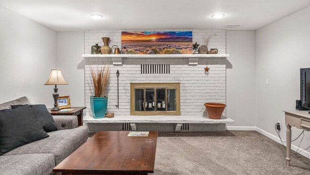Una sala de estar con chimenea, un sofá, una mesa de centro y un televisor.