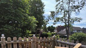Een houten terras met een houten omheining en een houten stoel.