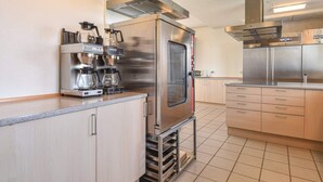 Eine moderne Küche mit Edelstahlgeräten, einer Kaffeemaschine und einem Backofen.