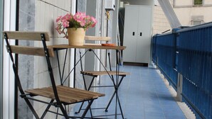 A corridor with blue tiled flooring, a wooden chair, and a table with a potted plant. - "Nicolini 39" Central, recently renovated, perfect for groups. (Napoli)
