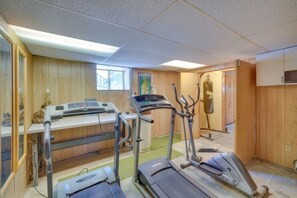 Ein Fitnessstudio mit Laufbändern, Crosstrainern und Rudergeräten.