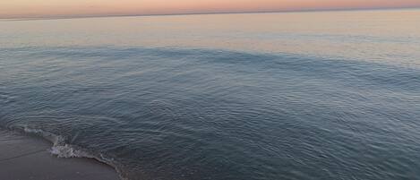 Una playa con agua tranquila y cielo despejado.