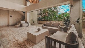 Amplia sala de estar con un gran ventanal, una escalera y una lámpara moderna.