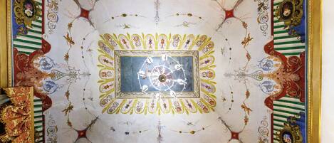 A ceiling with intricate designs and a central clock.