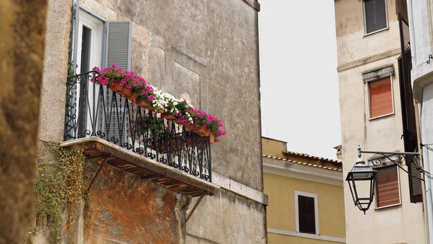 A balcony with flower boxes and a wrought iron railing.
