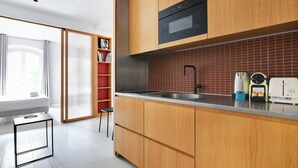 Eine moderne Küche mit Holzschränken, einer Edelstahlspüle und einem eingebauten Backofen.