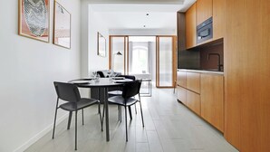 Eine moderne Küche mit Holzausstattung, einem eingebauten Ofen und einem Essbereich mit rundem Tisch und Stühlen.