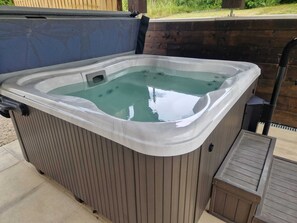 Un jacuzzi con revestimiento de madera y estructura metálica.