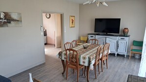 A dining area with a wooden table and chairs, a television, and a cabinet. - Comfortable gîte with spa and billiards near Beauval zoo (Saint-Aignan)