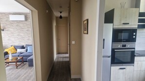 A modern kitchen with Bosch appliances, a wooden floor, and a sofa with cushions in the adjacent living area. - Comfortable gîte with spa and billiards near Beauval zoo (Saint-Aignan)
