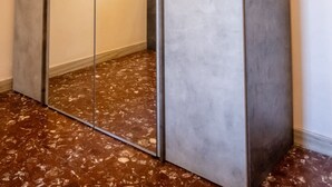 Un pasillo con un espejo grande y una obra de arte enmarcada.