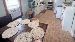 Una cocina con mesa de comedor, ventilador de techo y refrigerador.