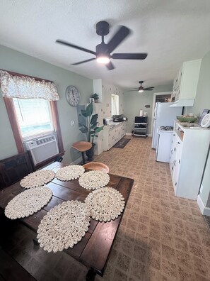 A kitchen with a dining table, ceiling fan, and a refrigerator. - Cozy 2-bedroom house in peaceful Medicine Lodge (Medicine Lodge)