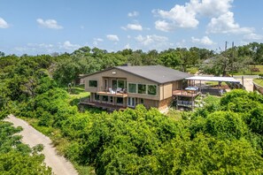 A modern house with a large deck, surrounded by lush greenery. - 3800sf Lake Front Home, Hot Tub, Next to Boat Ramp and Park, Centrally Located! (Belton)