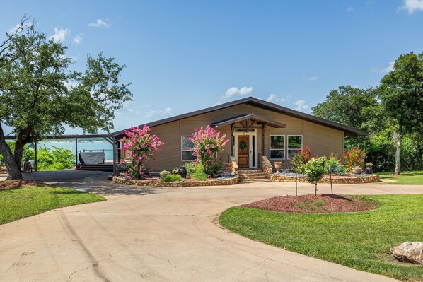 A single-story house with a front porch, a driveway, and a landscaped front yard. - 3800sf Lake Front Home, Hot Tub, Next to Boat Ramp and Park, Centrally Located! (Belton)