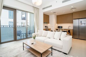 A modern living room with a sofa, coffee table, and a view of the balcony.