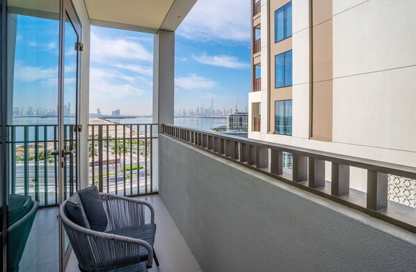 Un balcon donnant sur le panorama urbain, une chaise et une rambarde.