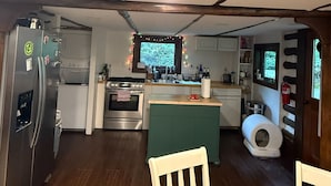 A compact kitchen with a refrigerator, stove, sink, and a small island.