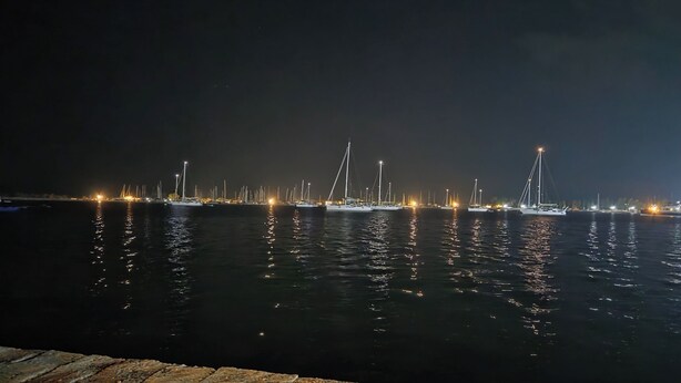 A marina at night with multiple boats docked and illuminated by lights. - Chrisa's Apartments Mesologgi (Mesolongi)