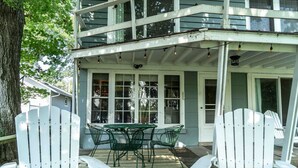 A covered porch with a table and chairs, a railing, and a view of the house. - Williams Bay Lakefront Retreat - Walk the Lakepath (Williams Bay)