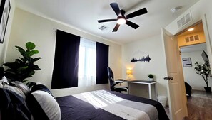 A hotel room with a bed, a desk, a chair, a ceiling fan, and a window with curtains. - ⭐️⭐️⭐️⭐️⭐️ Sleek Design. Elevated Stay｜15 min to Downtown! ✅️ (Las Vegas)