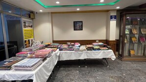 Une pièce dotée d’un sol en marbre, de tables sur lesquelles sont posés des classeurs, d’un panneau « Il est interdit de fumer » et d’un plafond équipé de luminaires encastrés.
