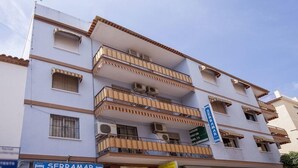 A multi-story building with balconies, air conditioning units, and a sign for 'SERRAMAR'. - Serramar (Benalmádena)