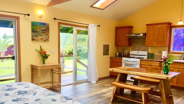 Una cocina amplia con armarios de madera, una mesa de comedor y un ventanal corredero que da a un balcón.