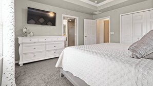 Un dormitorio con cama, cómoda, espejo y ventilador de techo.