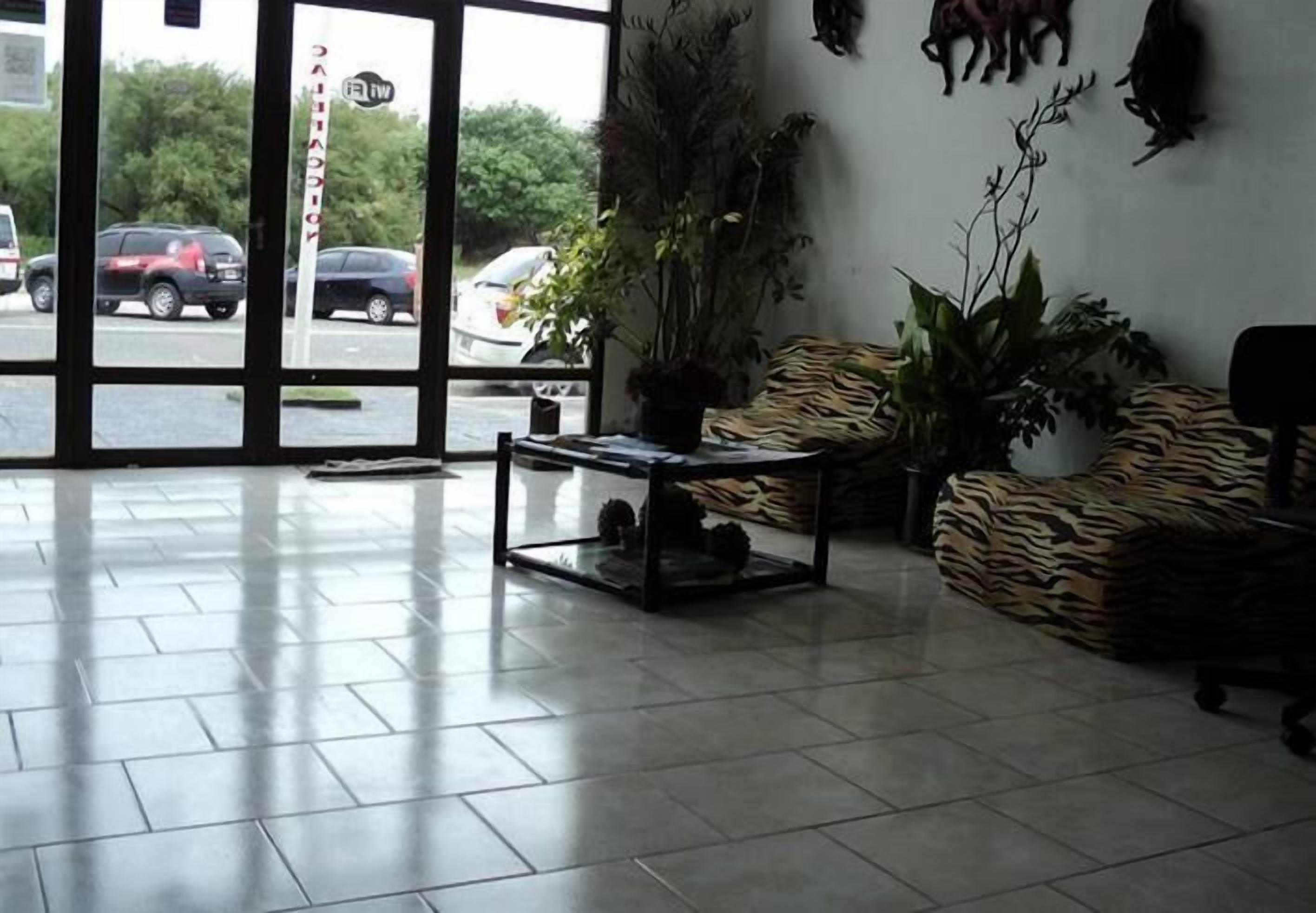 A lobby with a glass door, a glass coffee table, and a tiger-patterned sofa.