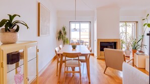 Un moderno comedor con una mesa y sillas de madera, una chimenea y plantas en macetas.