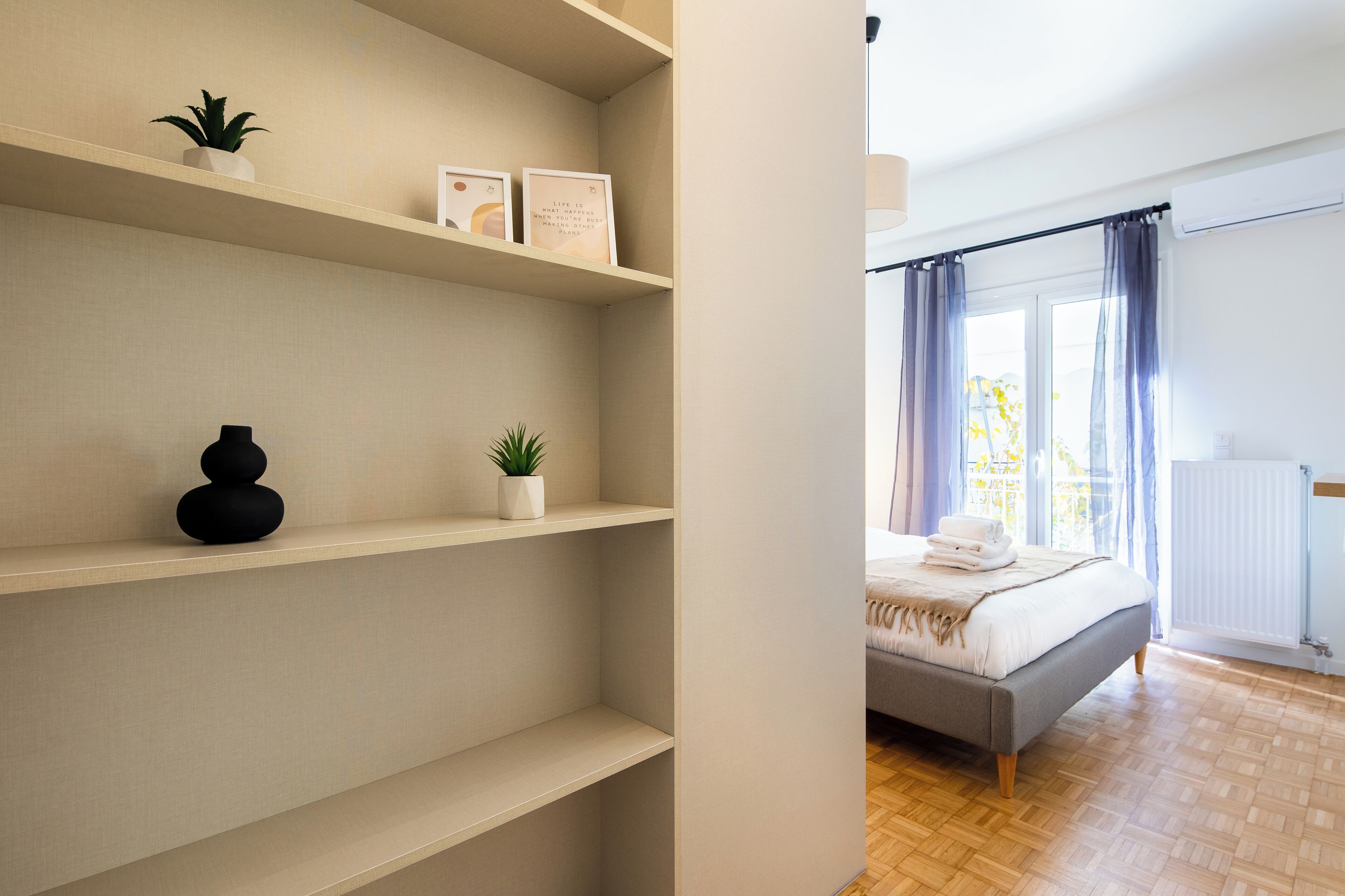 Een slaapkamer met een bed, een radiator en een raam met gordijnen.