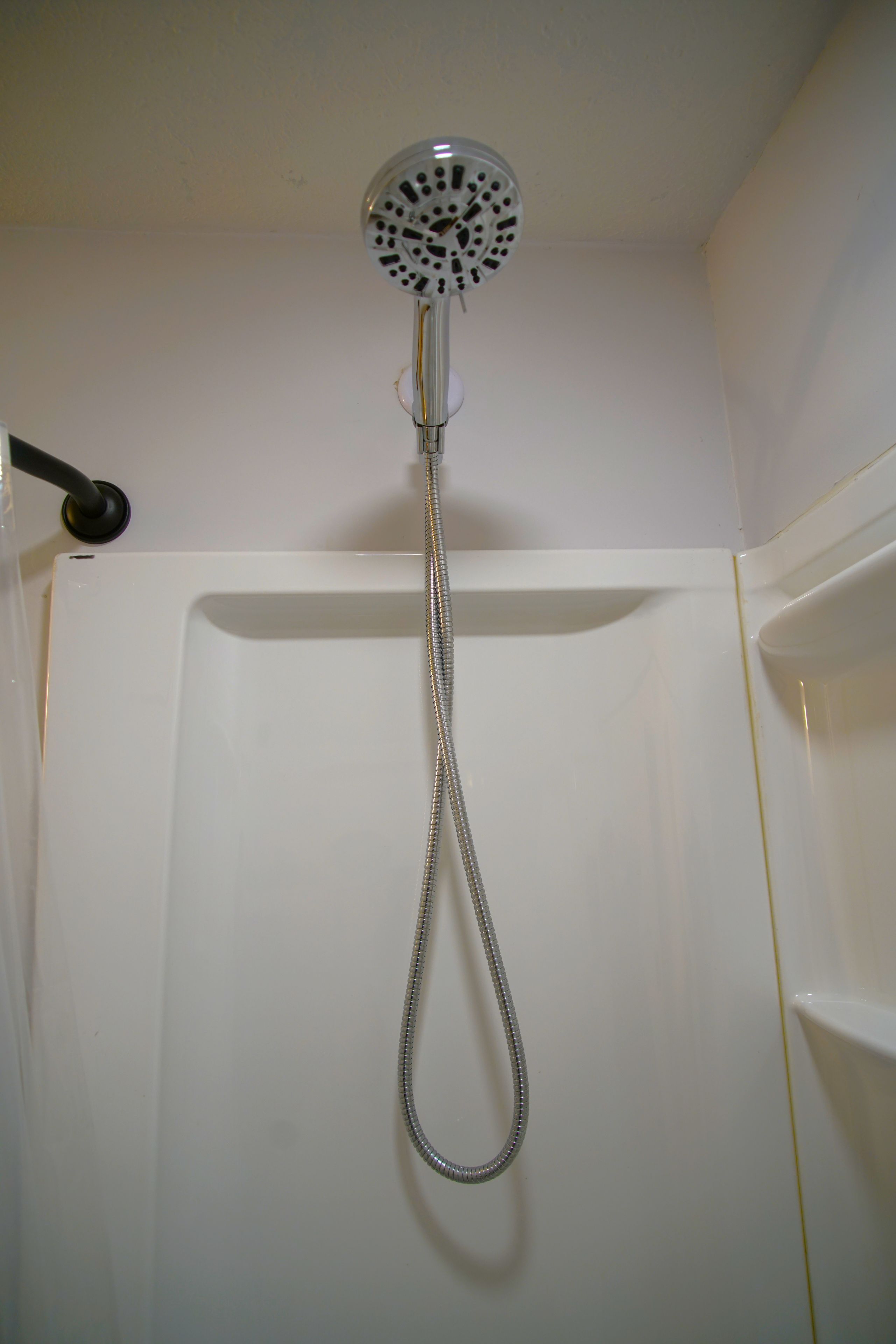 Une douche équipée d’un pommeau de douche et d’un flexible.