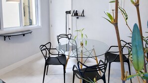 A modern dining area with a round glass table, black chairs, and a hanging pendant light. - PRIME location: Ipanema, Copacabana and Lagoa — all within reach (Lagoa Rio de Janeiro)