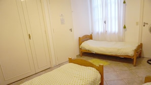 A room with two single beds, a wardrobe, and a window with curtains. - La Casa del Girasol Residencia Universitaria (Buenos Aires)