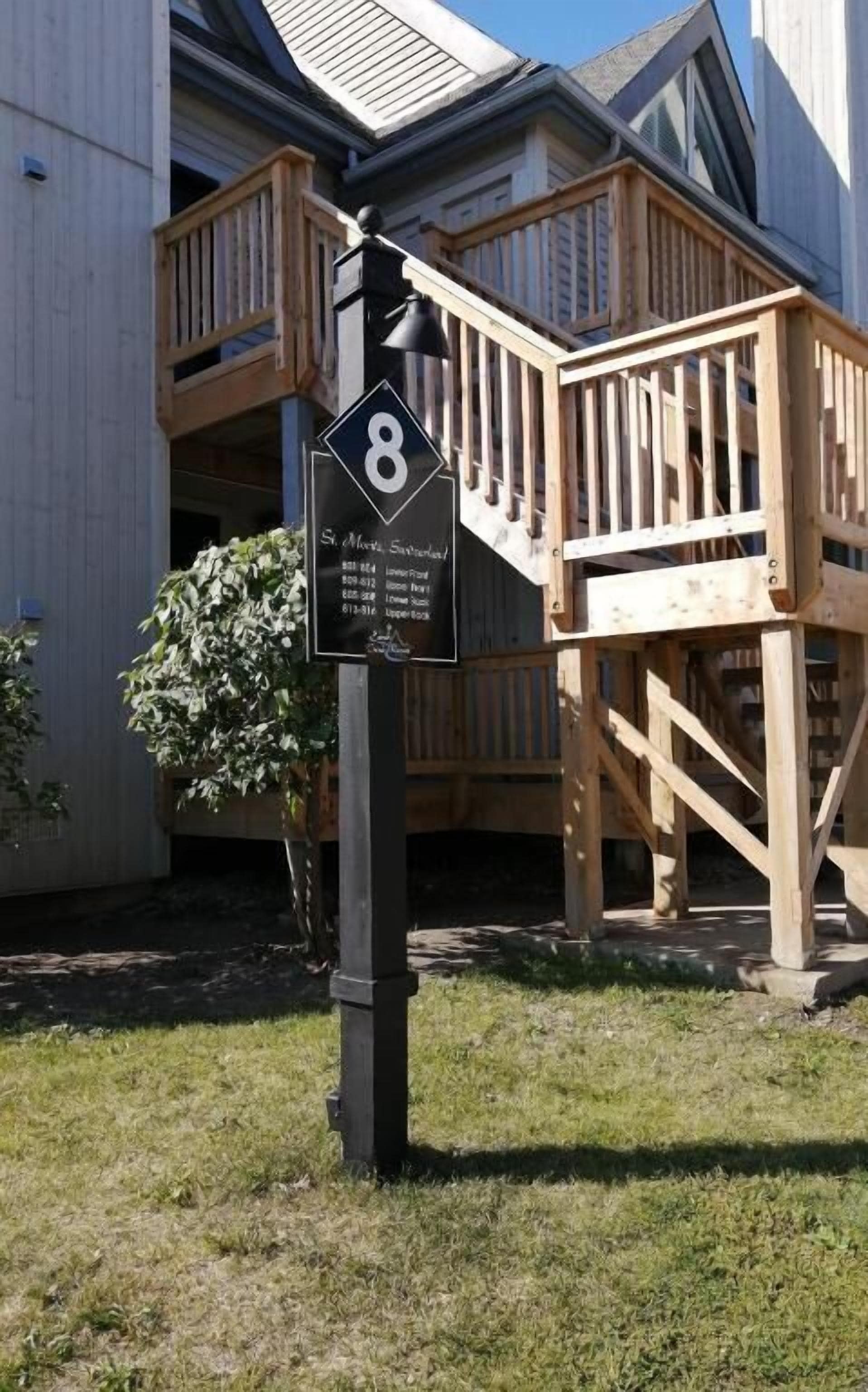 Une terrasse en bois sur laquelle est fixée une plaque noire portant le numéro 8.