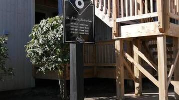 Une terrasse en bois sur laquelle est fixée une plaque noire portant le numéro 8.