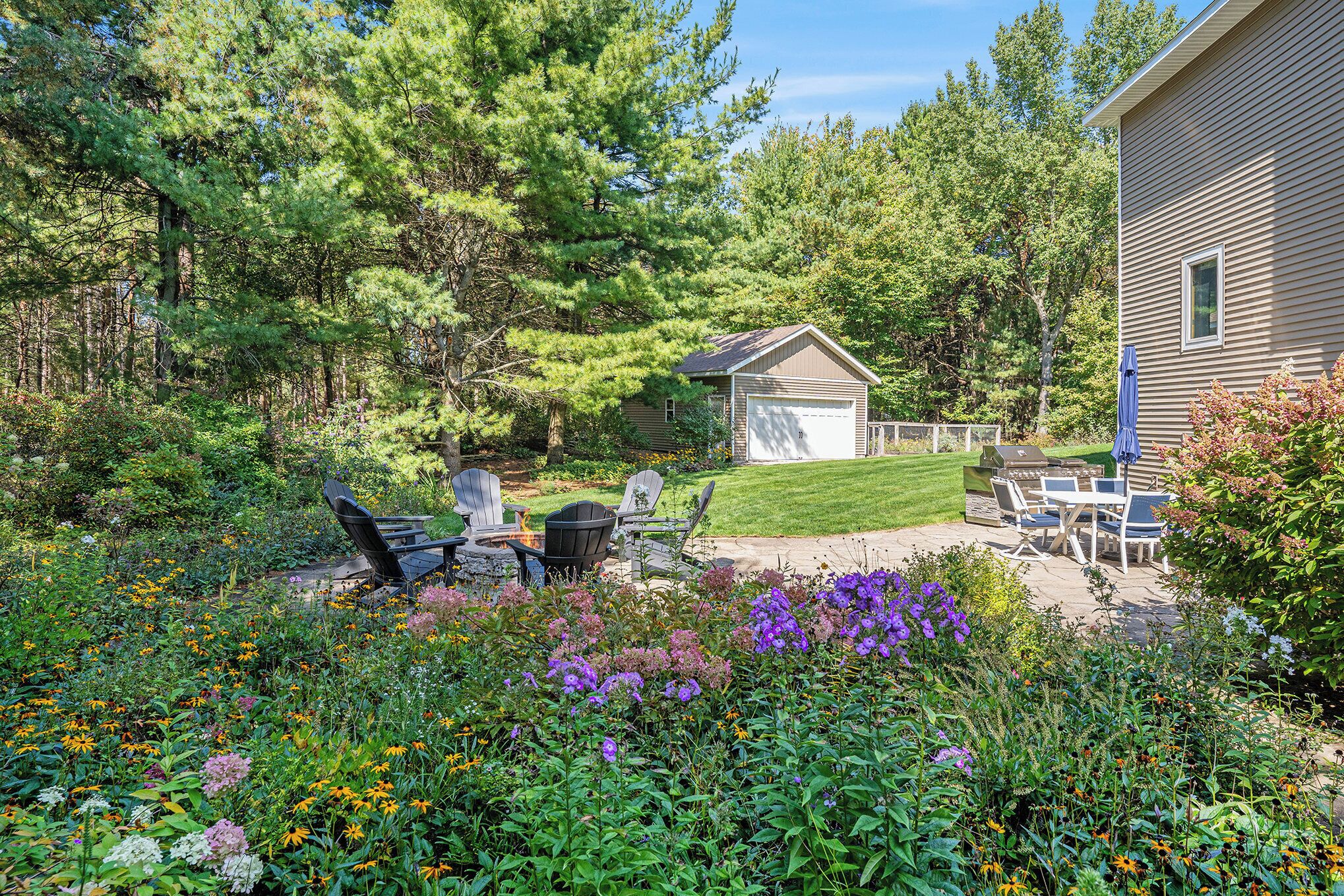 A backyard with a lawn, patio furniture, and a small shed.